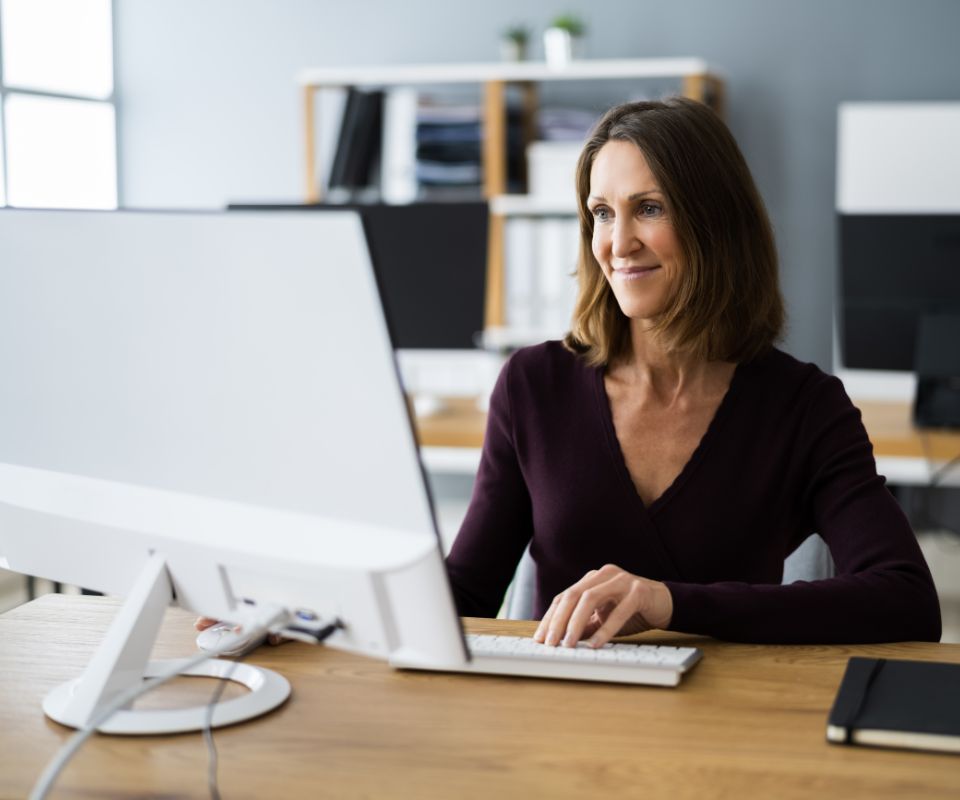 Mulher usando o computador, representando automação financeira e vantagens da API de pagamento