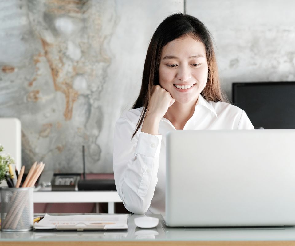 Mulher analisando a implementação da API de cobrança no computador